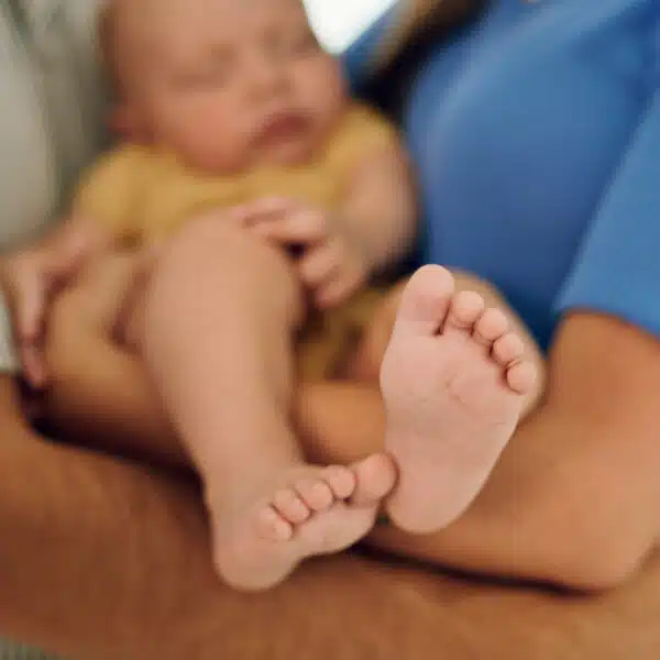 Novorođenče spava u naručju roditelja