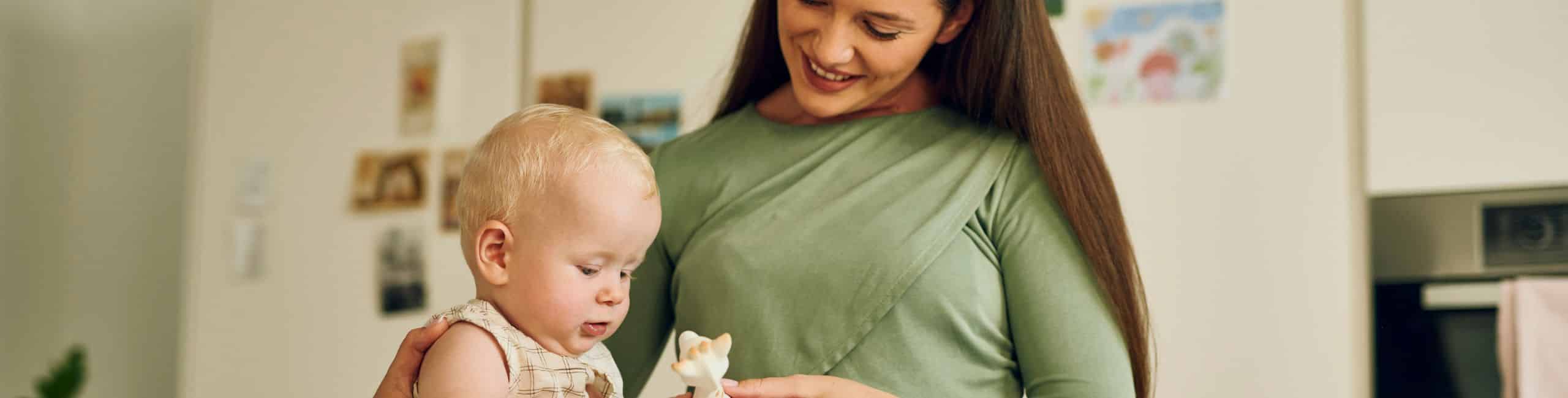 Majka s bebom u kuhinji igra se s popularnom žirafom - bezbrižni trenuci bez brige o alergijama