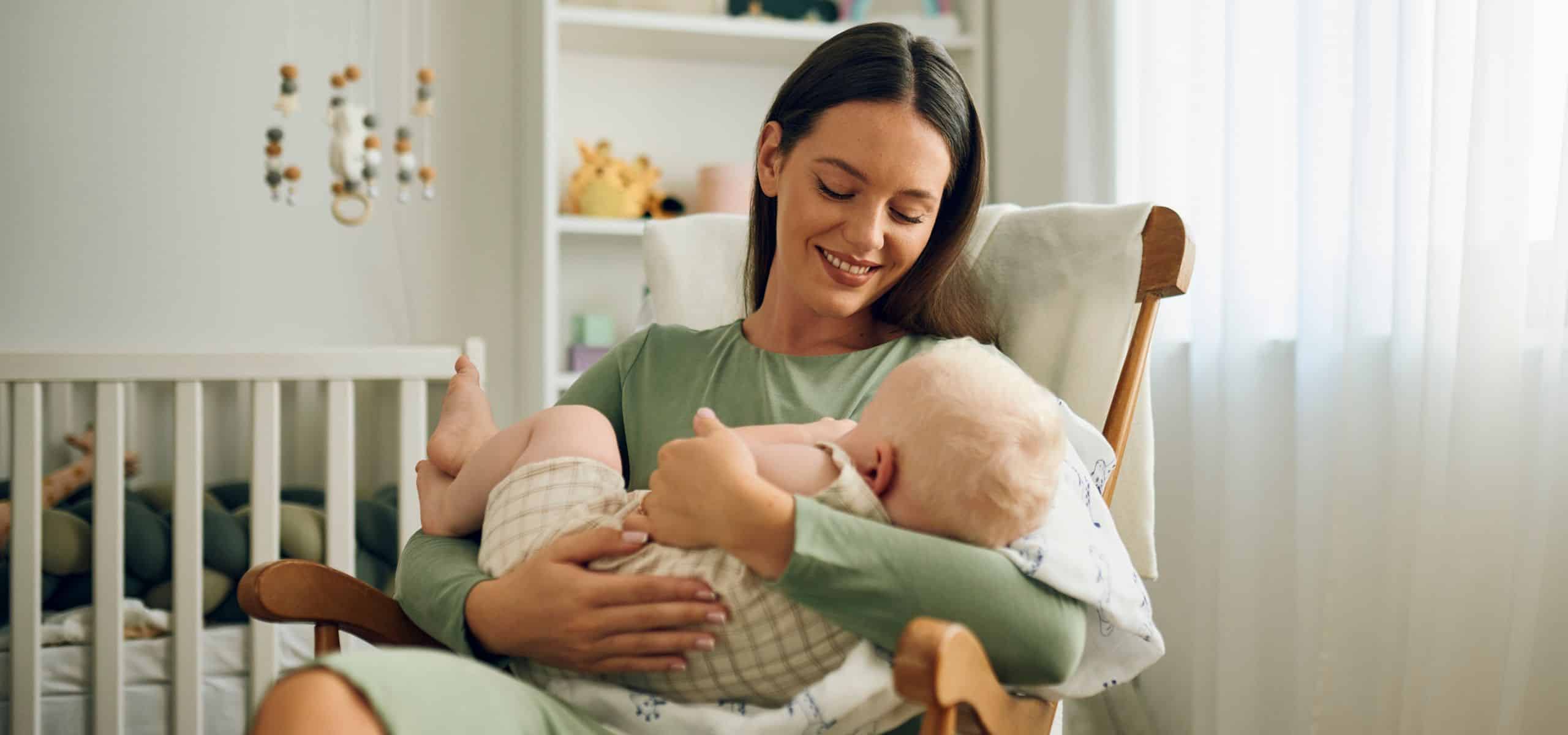 Majka drži bebu u naručju, priprema se za dojenje, nakon poroda.
