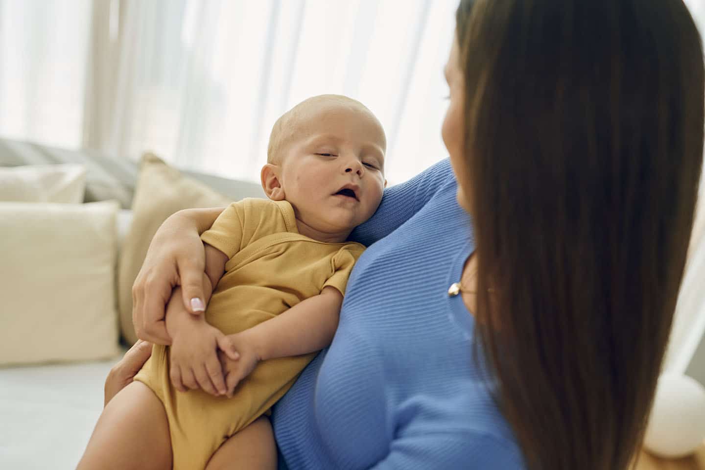 Majka u naručju drži usnulo dijete.