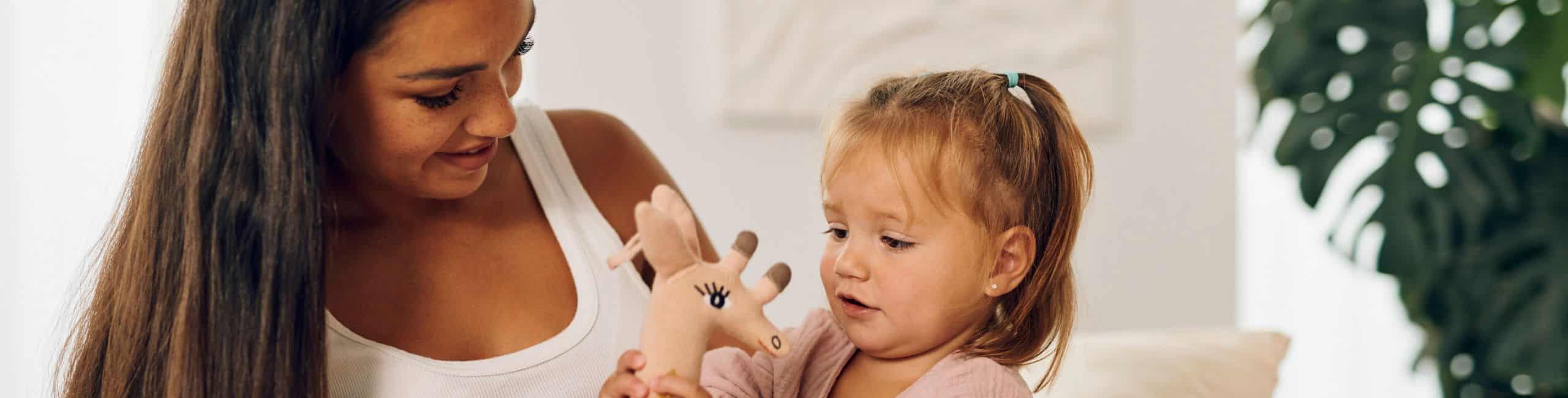 Trudna majka i dijete se igraju sa žirafom